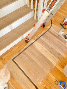 the flooring is being laid out on the wooden floors in front of the stairs