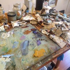 an easel is full of paint and other items on the table in front of it