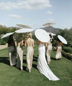 the bridesmaids are carrying umbrellas over their heads to protect them from the sun