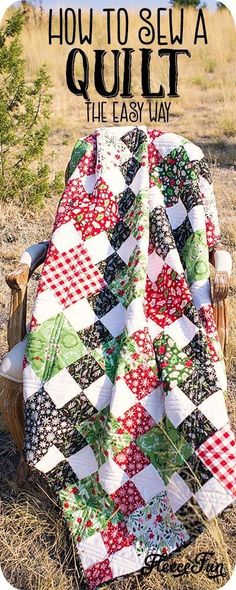 a quilt sitting on top of a wooden chair in the middle of a grass field