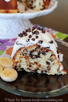 a piece of cake on a plate with banana slices and chocolate chips around the edge