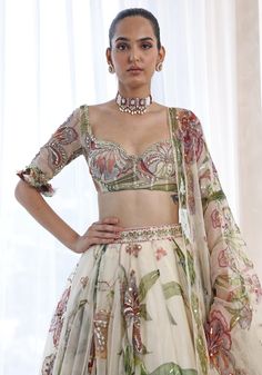 Featuring an ethereal ivory lehenga in a summer print and adorned with delicate embroidery. Paired perfectly with a matching classic blouse with a ruffle detail and a printed dupatta with glam sequins. This floral lehenga radiates elegance and grace and is ideal for a Sangeet or Mehendi at a destination party ! Composition : Lehenga, Blouse, Dupatta - Organza Care: Dry Clean Only and Vacuum Storage This product can be customized for sleeves, length of blouse and neckline Delivery : 4-6 weeks as the product is hand crafted. Check Size Guide or choose MySize for free customisation (All Sizes above XL can be made at 15% additional cost) For more information and sizes please contact fabiliciousfashion@gmail.com or visit our Copenhagen studio. About the Designer : Mahima Mahajan is best known f Ivory Lehenga, Mahima Mahajan, Lehenga Style Saree, Indian Bridesmaid Dresses, Simple Lehenga, Printed Lehenga, Floral Lehenga, Classic Blouse, Lehenga Style