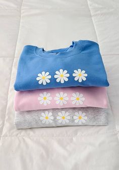 "This crewneck is soooo soft and cute! It has 3 daisies in the center and it comes in 3 different colors and 5 different sizes! ☆ DETAILS ☆ ▪︎ Available in blue, pink, and light gray. 💙 ▪︎ 50% Cotton, 50% Polyester ▪︎ Three 1.5\" daisy flowers 🌼 ▪︎ Available in sizes Small, Medium, Large, X Large, and XXL 👕 ▪︎ Gildan G180 Crewnecks ▪︎ Message me if you have any questions! 💕" Light Blue Sweatshirt For Spring Loungewear, Cute Sweatshirt For Spring Loungewear, Spring Light Blue Crew Neck Sweatshirt, Light Blue Crew Neck Sweatshirt For Spring, Trendy Light Blue Sweatshirt For Spring, Cute Crew Neck Sweatshirt For Loungewear, Cute Blue Sweatshirt With Relaxed Fit, Daisy Sweatshirt, Tie Dye Crewneck Sweatshirts