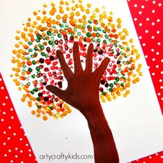 a handprinted tree is shown on a red and white paper with polka dots