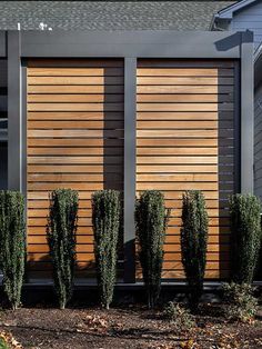 a modern house with wood slats on the side and plants growing out of it