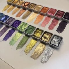 there are many different colored pigments in the box on the table, and one is empty