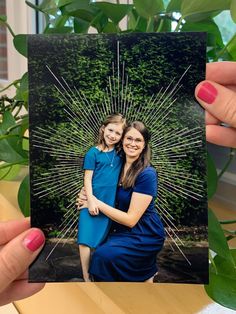 a woman holding up a card with an image of a mother and daughter