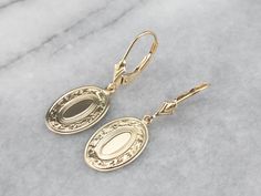 These beautiful earrings were handcrafted by our studio, using pieces of antique cufflinks! The handsome, sophisticated dangles are a beautiful yellow 14k gold that is chased with beautiful scrolling details! These date to the Victorian era! We've created bails and hung them on leverbacks of 14K yellow gold. Metal: 14K Yellow Gold Earrings Length: 32 mm Earrings Width: 11 mm Marks: “14K” Stamped on the reverse Formal Engraved Yellow Gold Earrings, Antique 14k Gold Hallmarked Earrings, Antique Yellow Gold Earrings For Formal Occasions, Antique Yellow Gold Earrings For Formal Events, Formal Engraved Drop Earrings, Victorian Engraved Yellow Gold Earrings, Victorian Style Engraved Yellow Gold Earrings, Polished Finish Drop Earrings For Wedding, Engraved Yellow Gold Drop Earrings