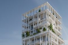 a tall white building with plants growing on the balconies