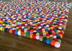 a multicolored area rug with pom - poms on the top and bottom