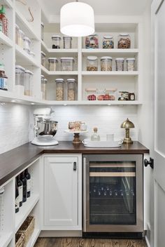 a kitchen with white cabinets and wood flooring is pictured in this image, the oven has been built into the wall