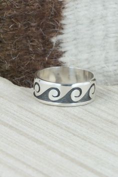 This sterling silver ring was made by Hopi silversmith Timothy Mowa.Size: 12.25Length: 3/8"Free shipping on all orders! We ship with USPS and always include tracking. All orders ship within a day of payment.Returns are accepted up to 30 days after you receive your order. Just send us a message. Our shop offers cash back or store credit. The item must be returned in new condition. Artisan Sterling Silver Engraved Hallmarked Ring, Symbolic Hand Forged Sterling Silver Rings, Sterling Silver Concave Ring Stamped 925, Artisan Sterling Silver Wide Band Ring, Artisan Sterling Silver Ring With Polished Finish, Artisan Sterling Silver Rings In White Gold, Artisan White Gold Rings In Sterling Silver, Artisan White Gold Sterling Silver Rings, Hand Forged Sterling Silver Engraved Ring