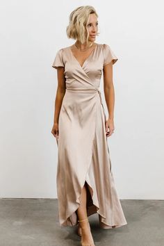 a woman wearing a beige wrap dress