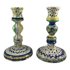 two colorful glass candlesticks sitting next to each other