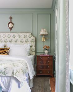 a bedroom with green walls and white bedding