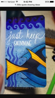 someone holding up a card with an image of a fish on it and the words just keep swimming