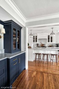 a kitchen with blue cabinets and wooden floors