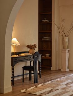 a room with a desk, chair and bookcase in it's center area