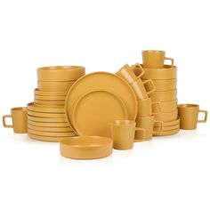 a stack of yellow dishes and cups on a white surface with one empty plate in the middle