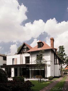 a large white house sitting on top of a lush green field