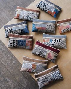 nine small zippered pouches sitting on top of a wooden table