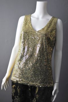 Simple sparkly gold sequin vest top from the early 2000s- pair with a black blazer for a glam evening look. Made from a metallic lurex type fabric, this has a bit of stretch to it but you might want to wear a cami under it if you have sensitive skin, as you might find it a little scratchy. No labels in this, but best fits up to a UK size 10 ( Bust=35 inches (88 cm) Waist=27 inches (68 cm) Hips=36 inches (93 cm) Garment Measurements; Bust= 38 inches (97 cm) Waist= 33 inches (84 cm) Hips= 37 inches (94 cm) Length shoulder to hem= 26 inches (66 cm) In great vintage condition, only flaw is some missing sequin dots in the armpits. Apologies for the terrible photos, I will try and add better ones! Fitted Shimmer Tank Top For Party, Elegant Gold Tank Top For Evening Events, Elegant Gold Tank Top For Evening, Gold Fitted Tank Top For Evening, Disco Style Sleeveless Evening Tops, Sleeveless Disco Tops For Evening, Fitted Gold Tank Top For Evening, Elegant Gold Tank Top For Party, Sparkling Sleeveless Top For Night Out