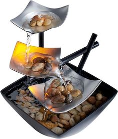 three tiered trays filled with rocks and water pouring from them to each other