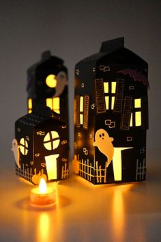 two paper houses are lit up with candles