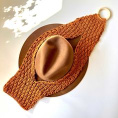 a brown hat and scarf on a white table