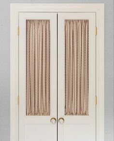 two white doors with striped curtains on them