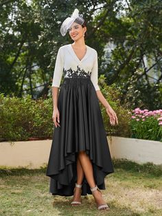 a woman in a black and white dress with a veil on her head is smiling at the camera