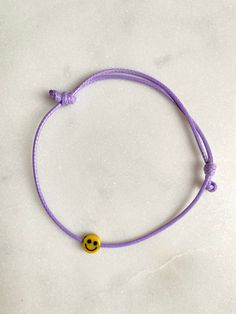 This adjustable bracelet not only will make you smile but also, its so soft you can wear it all day and night This bracelet is the perfect gift for a good friend and a kind reminder that, when we smile, our muscles can send feedback to our faces and help to boost our mood.   INGREDIENTS Nylon strap in purple Smiley: 5mm acrylic smile bead DIMENSIONS: Band one size, dimensions adjustable Diameter band: approx. 1.0 mm Smiley pendant approx. 5mm YOU CAN FIND MORE COOL BRACELETS HERE: https://www.et Cheap Everyday Friendship Bracelets With Smiley Face, Cheerful Adjustable Friendship Bracelets As Gift, Cheerful Adjustable Jewelry For Friendship, Casual Bracelets With Sliding Knot For Gift, Casual Purple Friendship Bracelets As Gift, Cheerful Adjustable Jewelry For Gifts, Casual Sliding Knot Bracelets As Gift, Casual Sliding Knot Bracelets For Gift, Casual Sliding Knot Bracelet As Gift