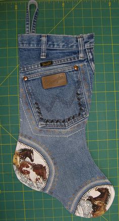 a pair of jeans with horses on them are sitting on a cutting board next to scissors