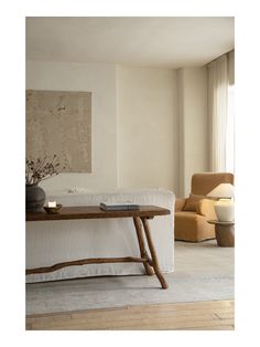 a living room filled with furniture and a painting hanging on the wall over a coffee table