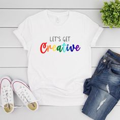 Let's Get Creative Shirt Art Teacher Shirt Creator | Etsy White Pre-shrunk Top For Pride, Multicolor Cotton Shirt For Pride, Multicolor Graphic Print Shirt For Pride, Pride Funny Print Cotton Top, Funny Print Cotton Top For Pride, Cotton Graphic Print Pride Shirt, Fun Cotton Tops For Pride, Cotton Graphic Print Shirt For Pride, Graphic Print Cotton Shirt For Pride