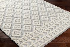 a white area rug on top of a wooden floor