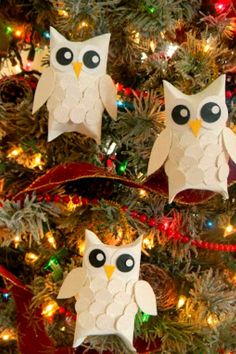 two paper owls sitting on top of a christmas tree