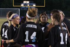 a group of young women standing next to each other on a field