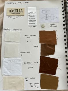 an open notebook with some brown and white papers on it, including different colored swatches