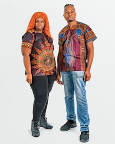 A man and a woman posing in multi colored African print shirts. Relaxed Fit Short Sleeve Batik Print Top, Relaxed Fit Batik Print Top With Short Sleeves, Relaxed Fit Short Sleeve Batik Top, Relaxed Fit Short Sleeve Top With Batik Print, Printed Short Sleeve Blouse For Festival, Mid Thigh Dress, Dashiki Shirt, Ankara Print, African Ankara