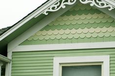 a green house with white trim and a window