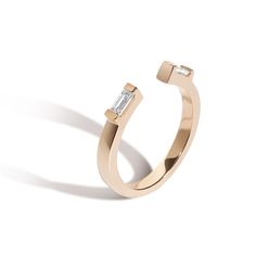 a gold ring with two diamonds on it