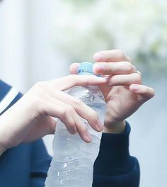 a woman is holding a bottle of water