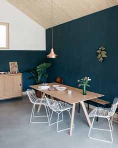 two pictures of a dining room with chairs and a table in the middle one has a potted plant on it