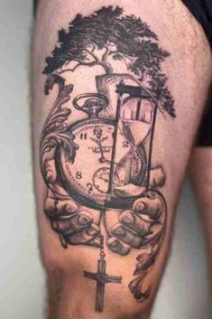 a man's thigh with a clock and cross tattoo on the side of his leg