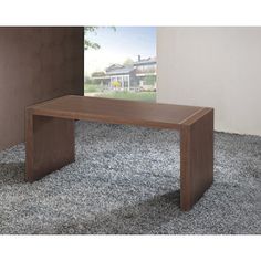 a wooden table sitting on top of a carpeted floor in front of a window