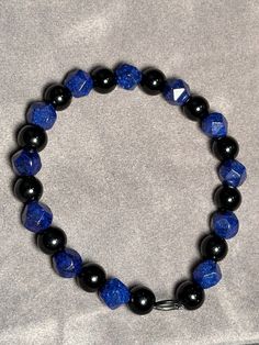 Royal blue glass beads alternating with smooth round black beads. Black And Blue Bracelet, Casual Large Blue Beads, Blue Faceted Beads Casual Style, Blue Jewelry With Round Black Beads, Blue Round Beaded Bracelets With Faceted Beads, Casual Black Gemstone Beads, Adjustable Blue Beaded Bracelets With Black Beads, Middle Island, The Color Blue