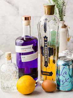 the ingredients for an alcoholic cocktail are displayed on a table with purple and blue accents