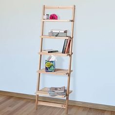 a wooden shelf with books and magazines on it in a room next to a blue wall