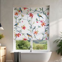 a bathroom window with flowers and birds painted on the blinds above it, next to a bathtub